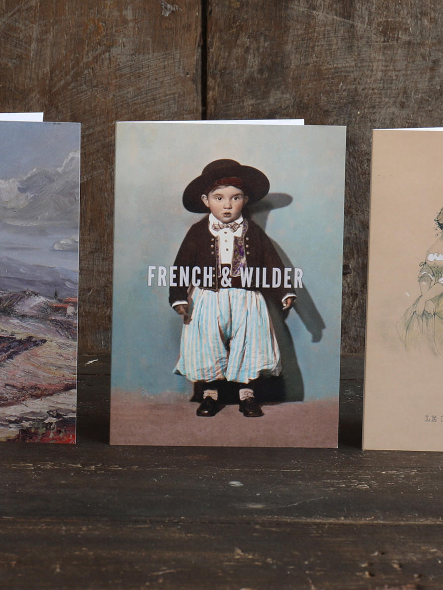 Five vintage-style greetings cards with French themed illustrations on a wooden surface.