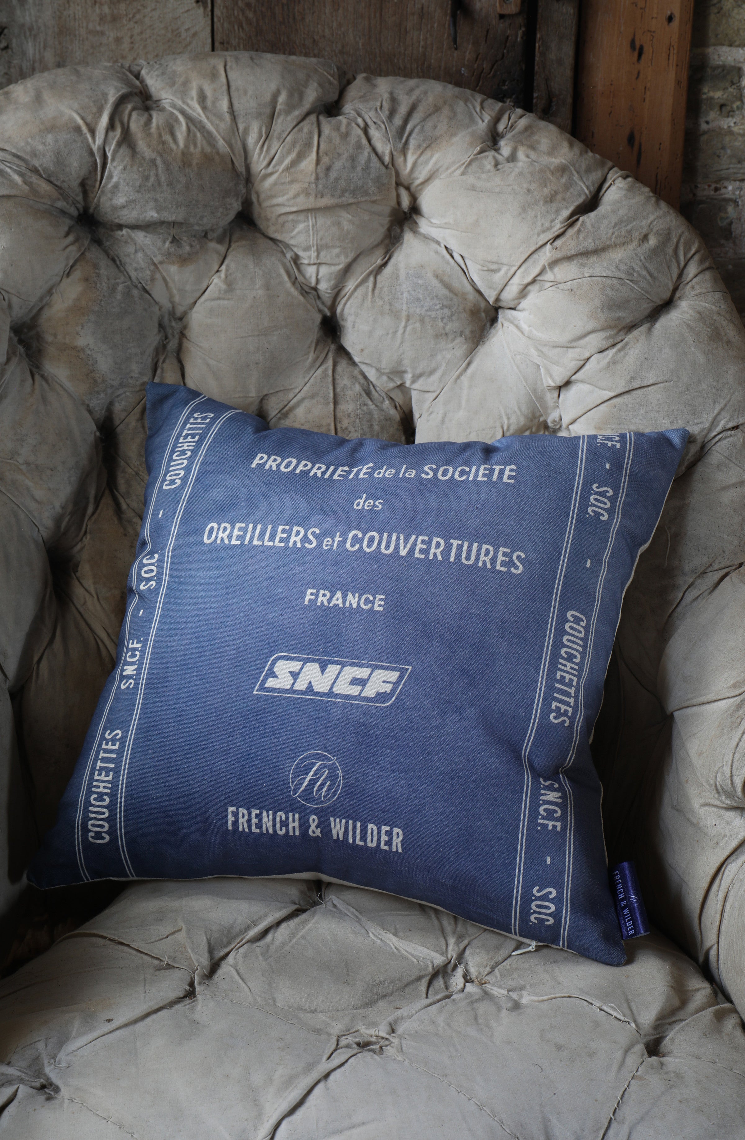 Cushion with blue and while SNCF branding on a textured chair