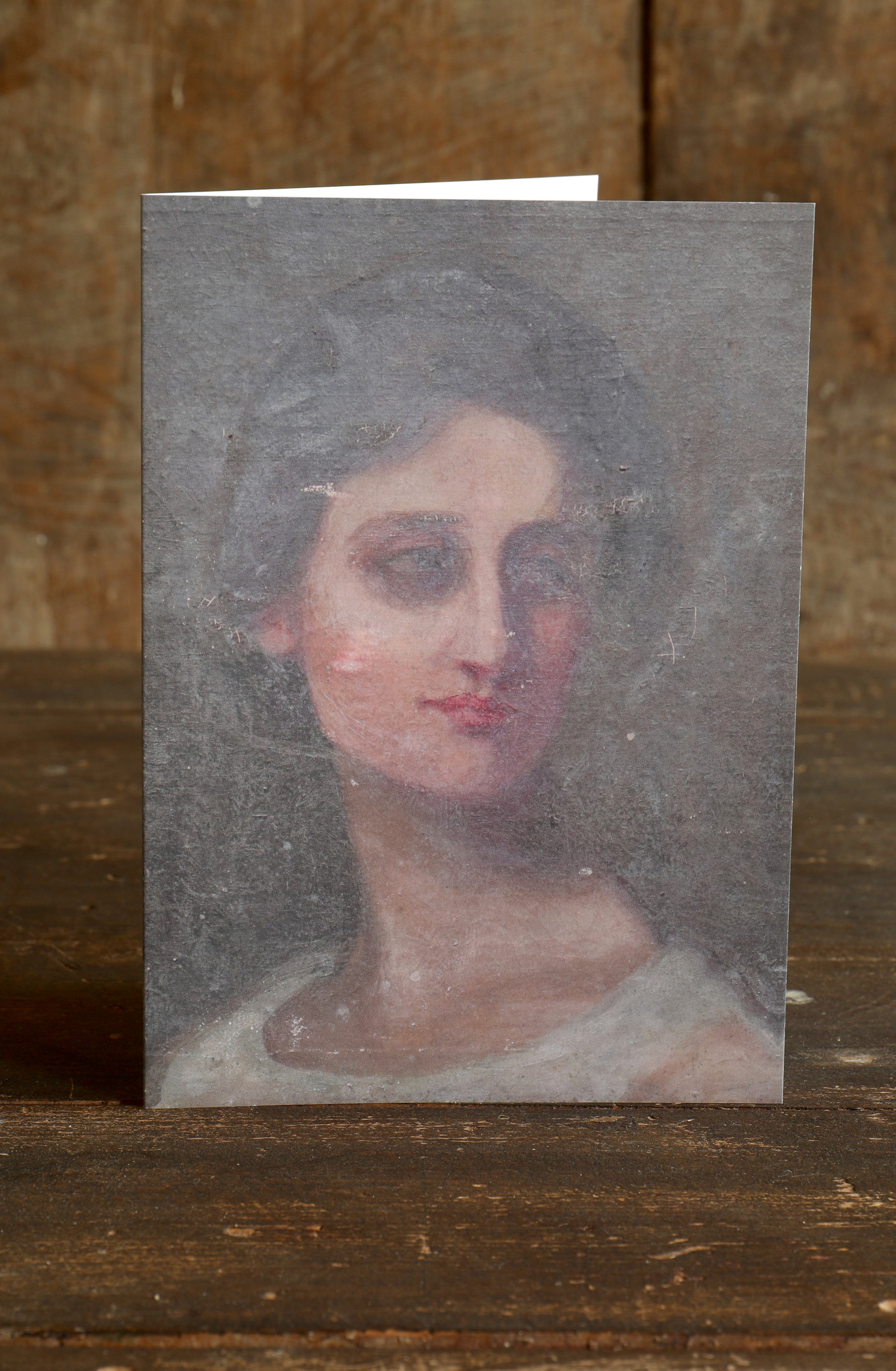 Greetings card with a vintage portrait of a demure woman against a wooden background