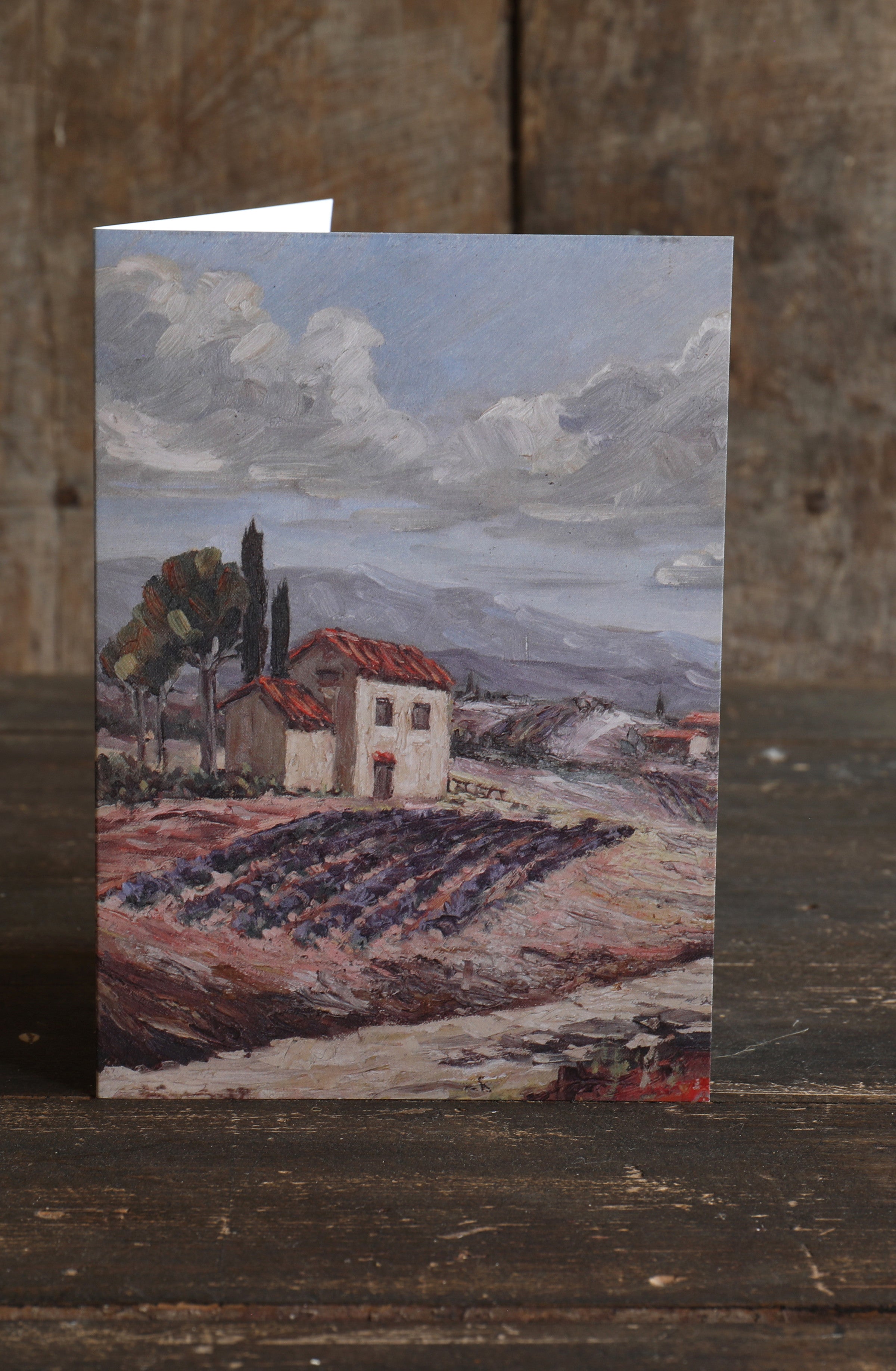 Greetings card featuring a painted Provence landscape with a house and lavender fields on a wooden surface
