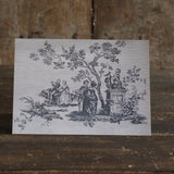 Greetings card with a textured vintage toile de jouy design of an illustration of people around a tree on a wooden surface.