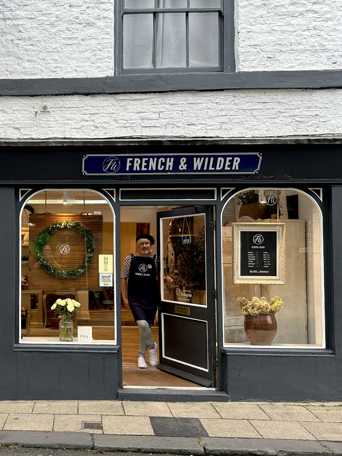 Storefront with large window display featuring homeware and fashion items and a sign for 'French & Wilder'.